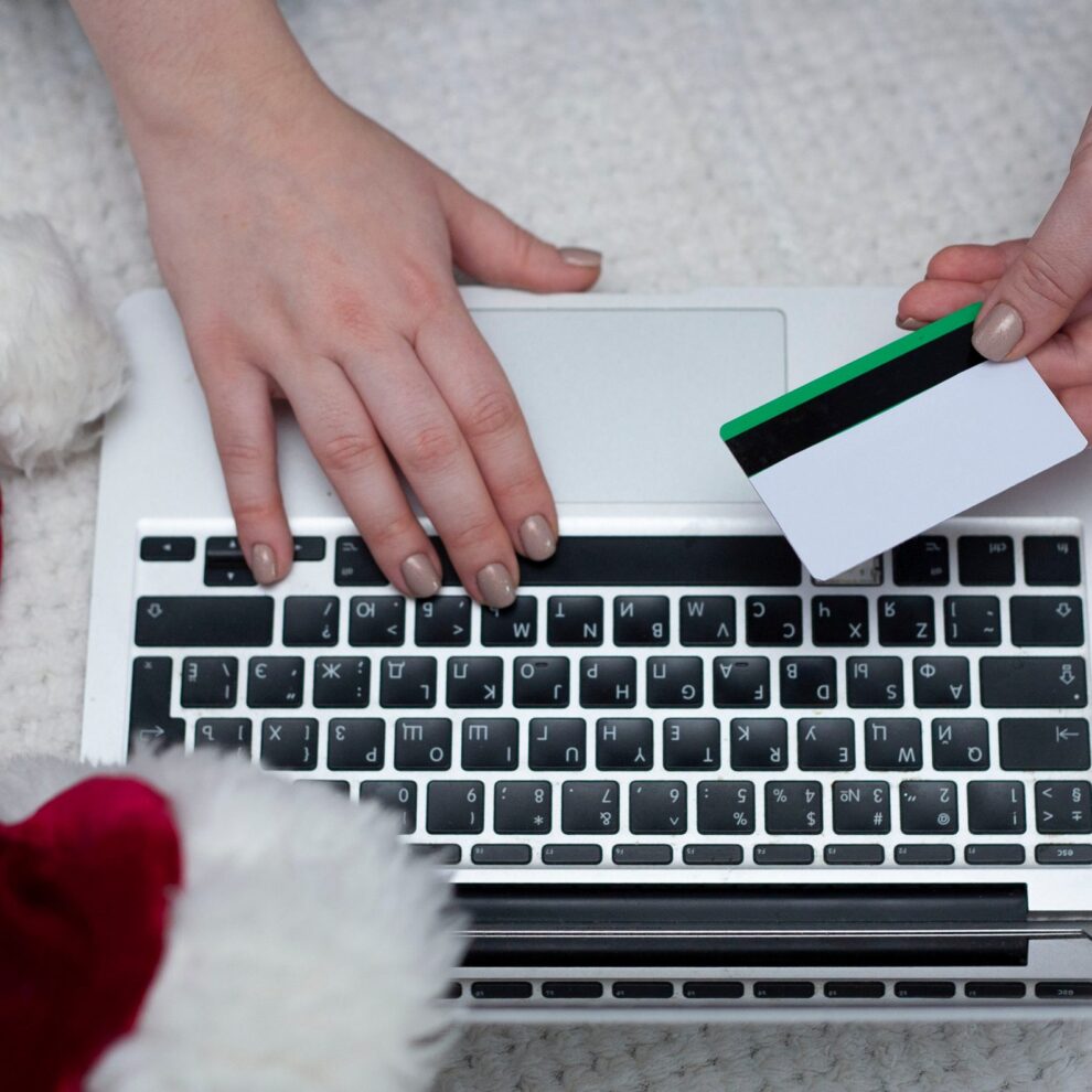 A woman orders gifts over the Internet. A woman’s hand holds a c